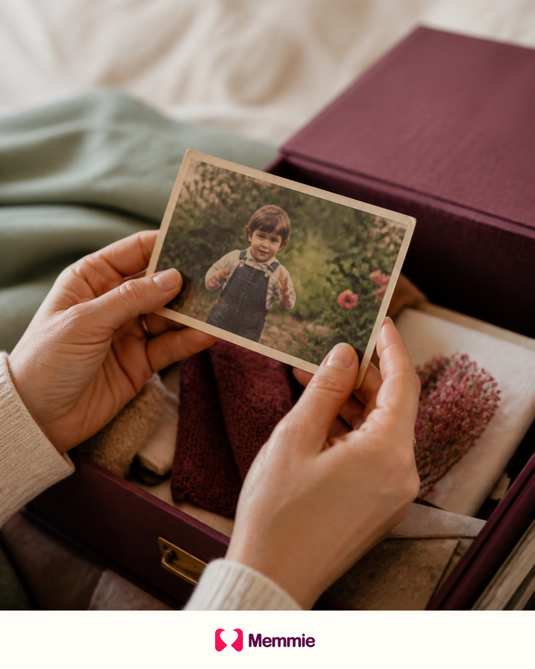 Hands holding a childhood photograph above a family memory box.